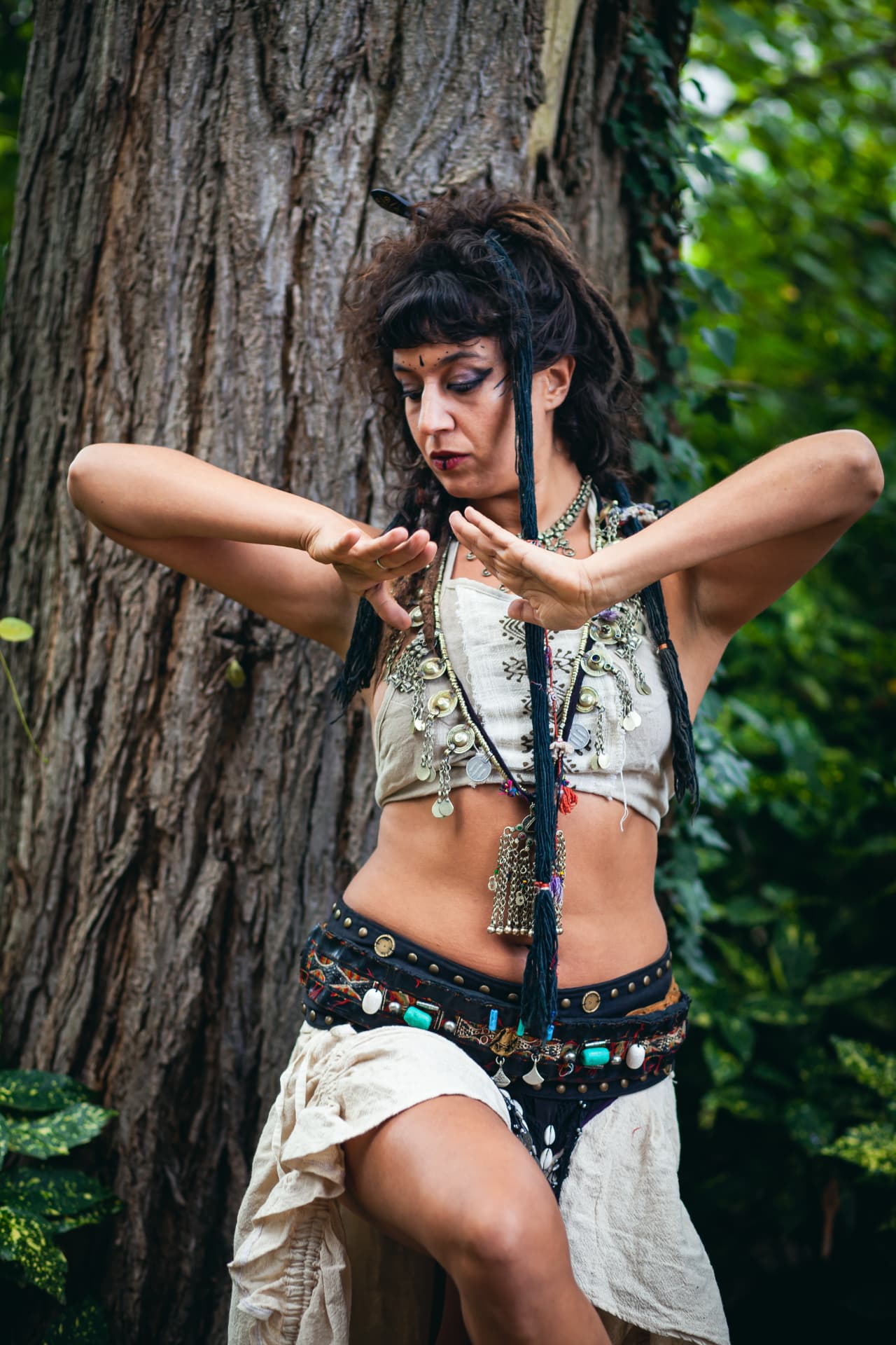 Laila in tribal fusion kostuum met gekruiste handen voor een boom